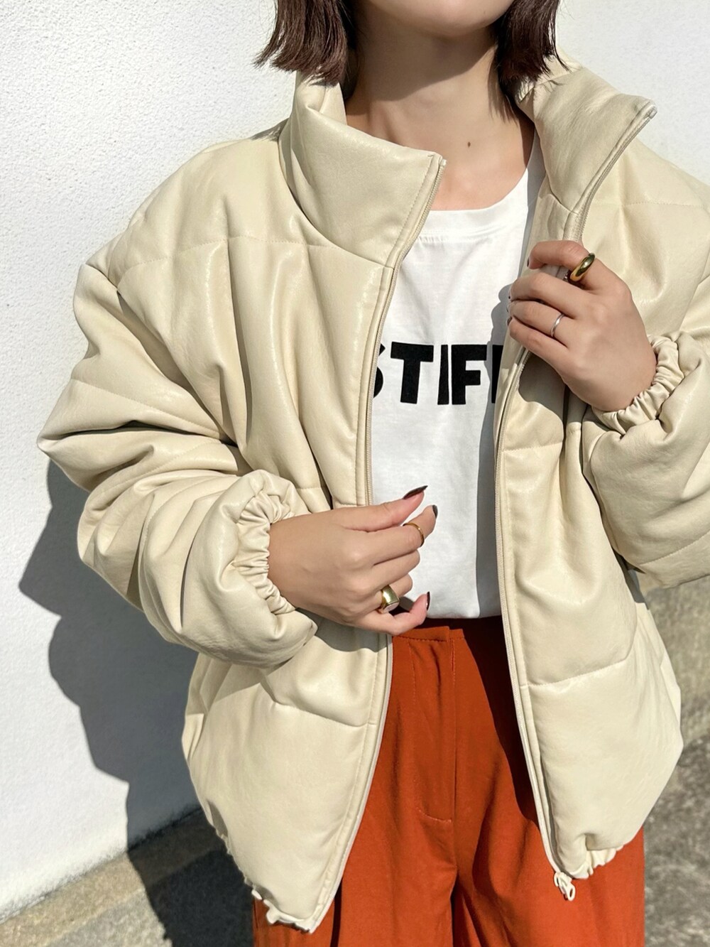 ホワイト系のダウンジャケット/コート、ホワイト系のTシャツ/カットソー、ブラウン系のその他パンツを着用したレディースの秋コーディネートの4枚目の写真
