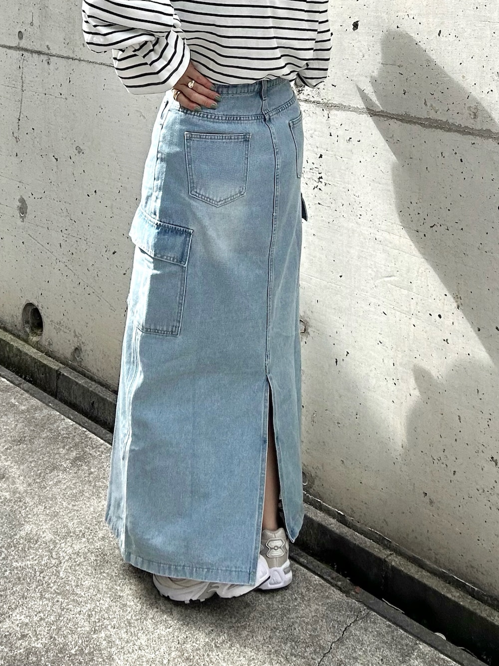 ホワイト系のTシャツ/カットソー、ブルー系のデニムスカート、ベージュ系のスニーカーを着用したレディースの春コーディネートの4枚目の写真