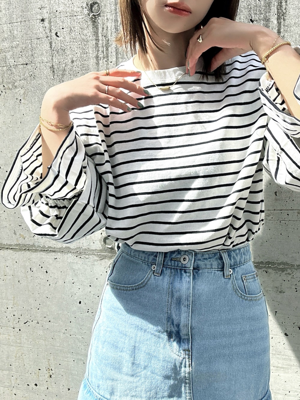 ホワイト系のTシャツ/カットソー、ブルー系のデニムスカート、ベージュ系のスニーカーを着用したレディースの春コーディネートの5枚目の写真