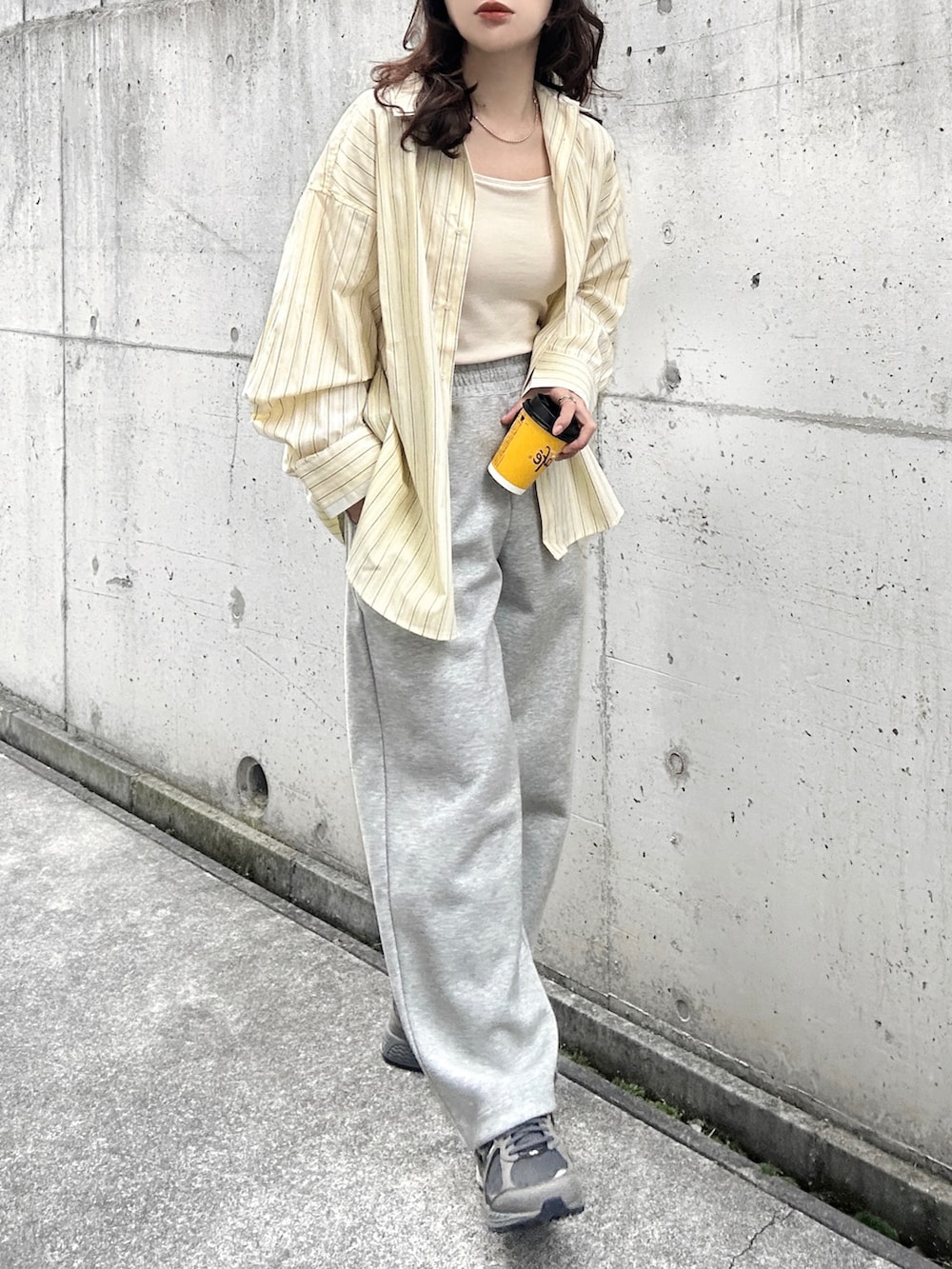 イエロー系のシャツ/ブラウス、ホワイト系のキャミソール、グレー系のスニーカーを着用したレディースの冬コーディネートの3枚目の写真