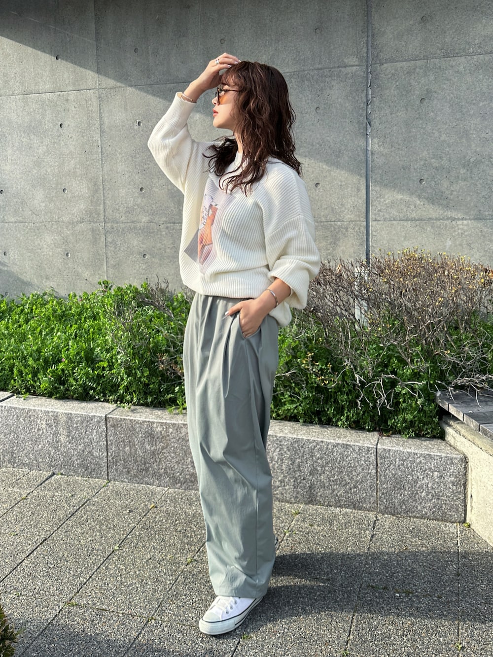 ホワイト系のニット/セーター、グリーン系のチノパンツ、ホワイト系のスニーカーを着用したレディースの春コーディネートの4枚目の写真