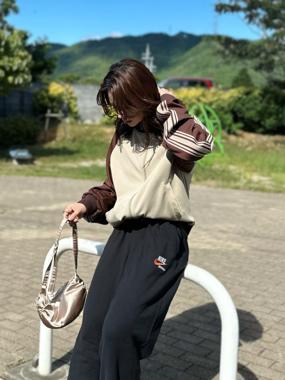 ベージュ系のジャージ、ブラック系のスウェットパンツ、ブラウン系のスニーカーを着用したレディースの秋コーディネートの2枚目の写真