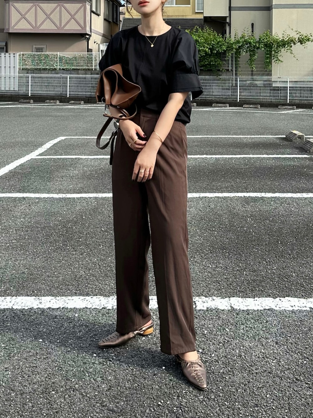ブラック系のTシャツ/カットソー、ブラウン系のその他パンツ、ブラウン系のバッグを着用したレディースの夏コーディネートの2枚目の写真
