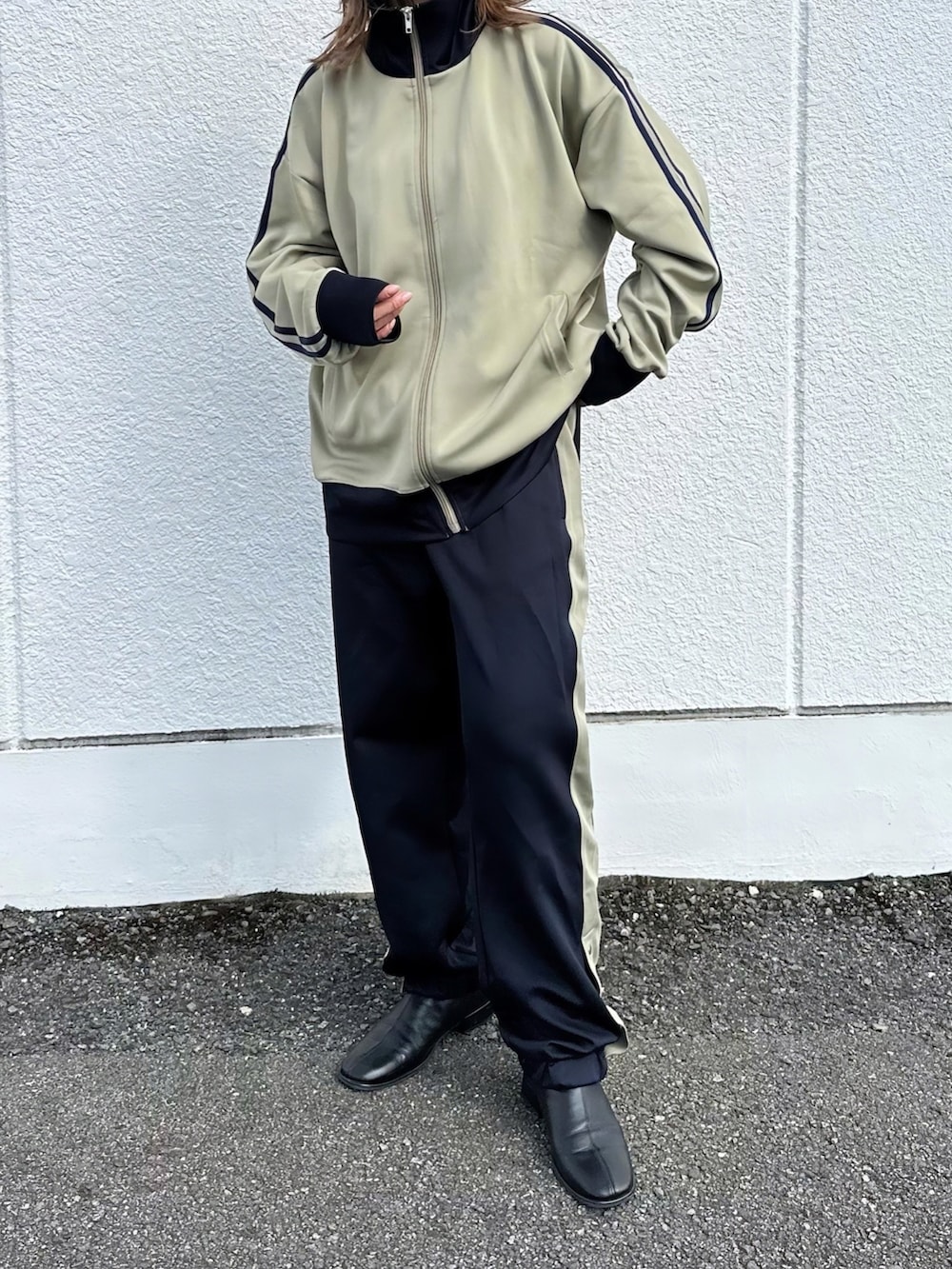 ベージュ系のジャージ、ブルー系のスウェットパンツ、ブラック系のその他シューズを着用したレディースの秋コーディネートの4枚目の写真