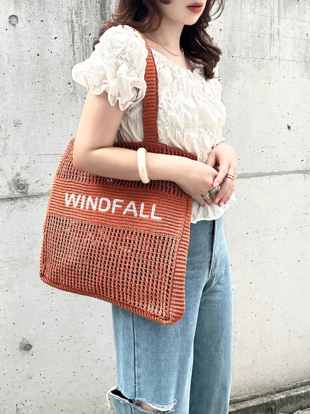ホワイト系のシャツ/ブラウス、レッド系のトートバッグ、ブルー系のデニムパンツを着用したレディースの夏コーディネートの2枚目の写真