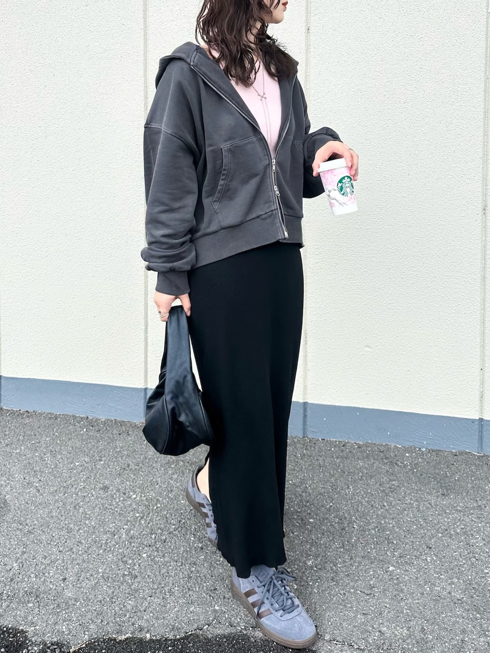 グレー系のパーカー、ピンク系のタンクトップ、ブラック系のスカートを着用したレディースの春コーディネートの2枚目の写真