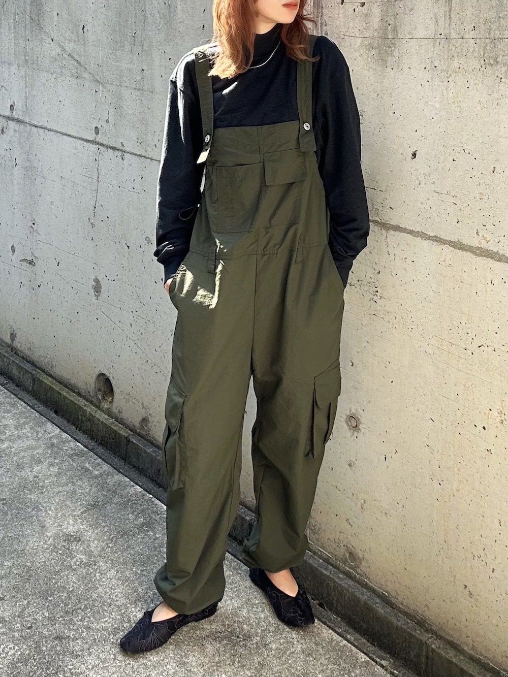 グリーン系のオールインワン・サロペット、ブルー系のTシャツ/カットソー、グレー系のニット/セーターを着用したレディースの秋コーディネートの3枚目の写真