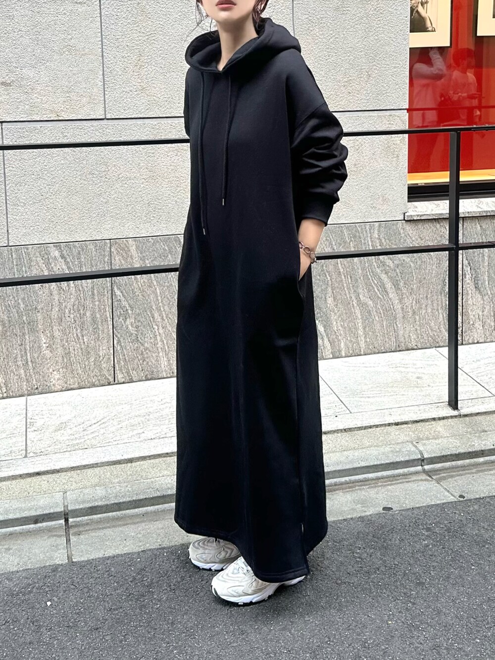 グリーン系のノーカラージャケット、ブラック系のワンピース、ベージュ系のスニーカーを着用したレディースの秋コーディネートの5枚目の写真