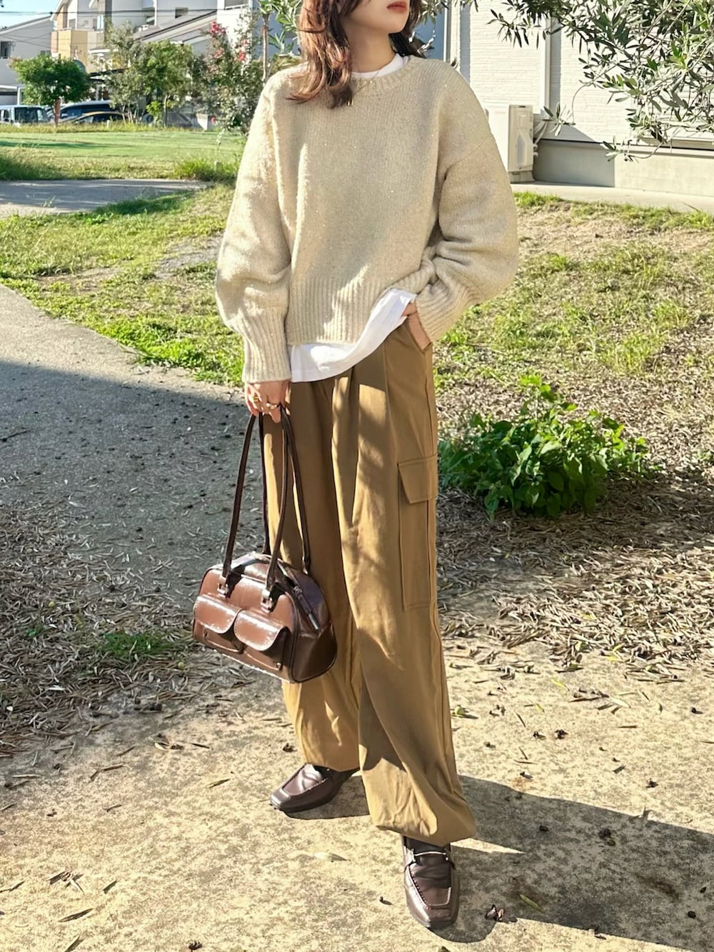 ベージュ系のニット/セーター、ブラウン系のパンツ、ブラウン系のショルダーバッグを着用したレディースの秋コーディネートの3枚目の写真