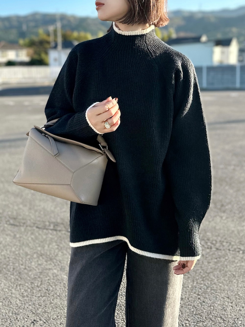 ホワイト系のダウンジャケット/コート、ブラック系のニット/セーター、ブラック系のデニムパンツを着用したレディースの秋コーディネートの3枚目の写真