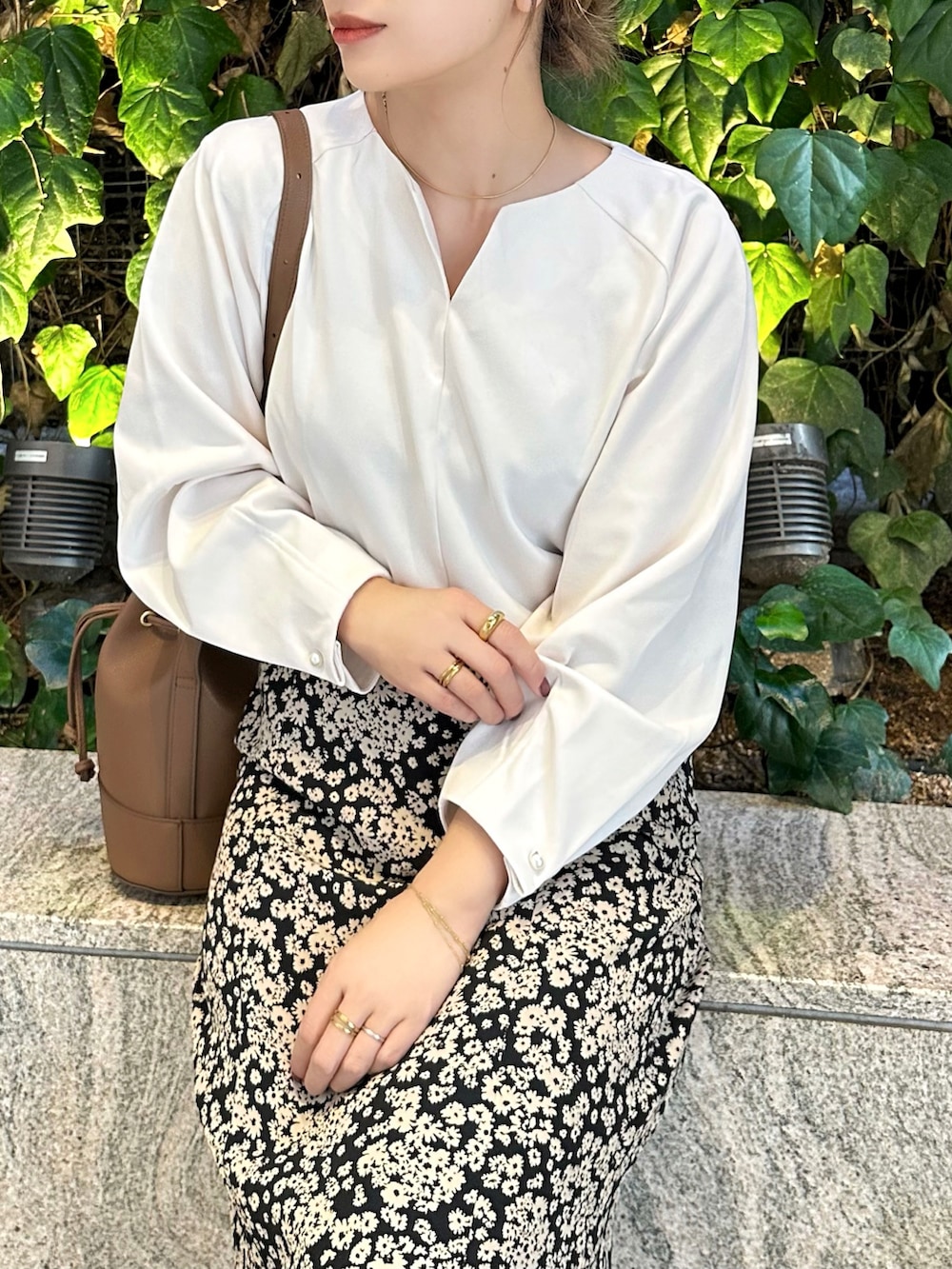 ホワイト系のTシャツ/カットソー、ブラック系のスカート、ブラウン系のショルダーバッグを着用したレディースの秋コーディネートの2枚目の写真