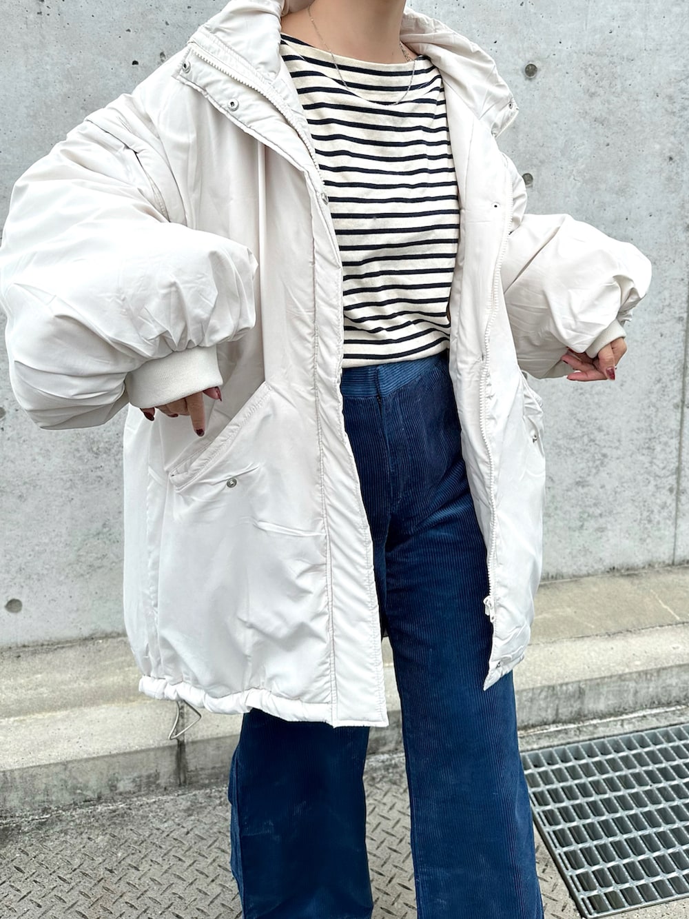 ホワイト系のダウンジャケット/コート、ブルー系のパンツ、ブラック系のスニーカーを着用したレディースの秋コーディネートの4枚目の写真