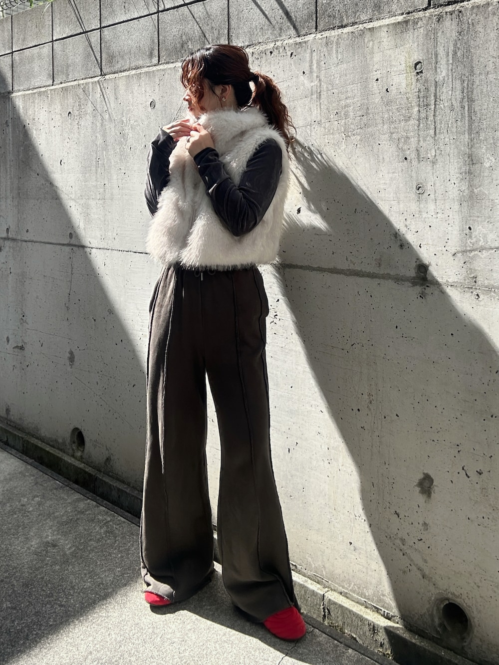 ホワイト系のベスト、グレー系のTシャツ/カットソー、ブラック系のスウェットパンツを着用したレディースの秋コーディネートの3枚目の写真