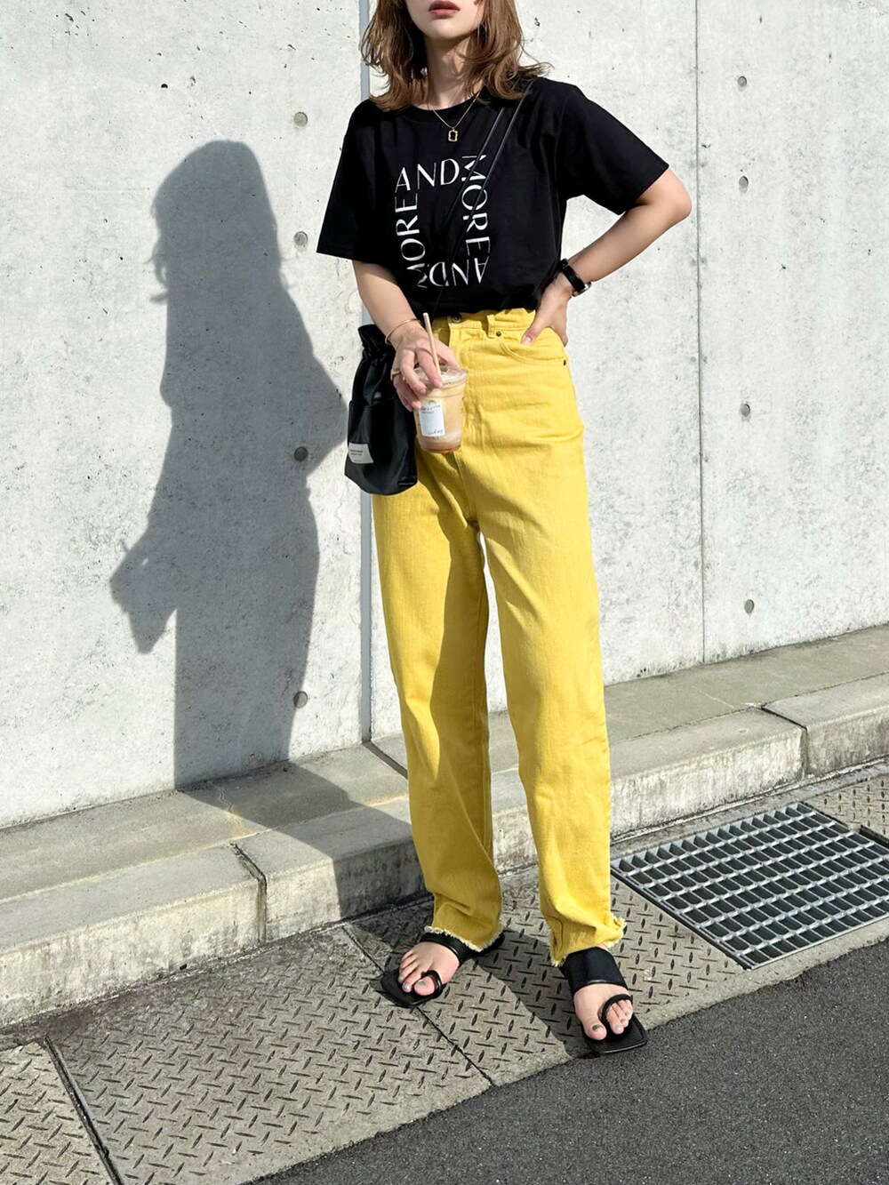 ブラック系のTシャツ/カットソー、イエロー系のデニムパンツ、ブラック系のショルダーバッグを着用したレディースの夏コーディネートの3枚目の写真