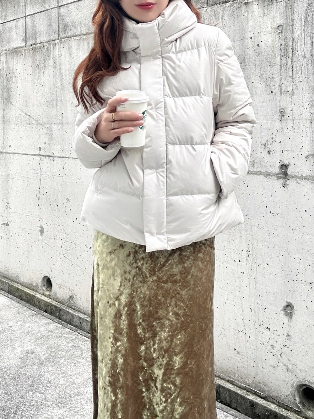 ホワイト系のブーツ、ホワイト系のダウンジャケット/コート、ベージュ系のスカートを着用したレディースの冬コーディネートの4枚目の写真