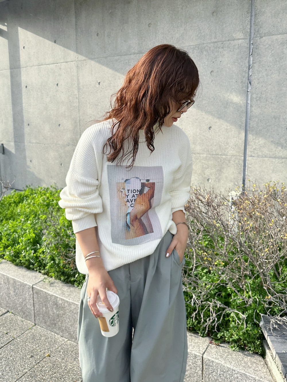 ホワイト系のニット/セーター、グリーン系のチノパンツ、ホワイト系のスニーカーを着用したレディースの春コーディネートの3枚目の写真