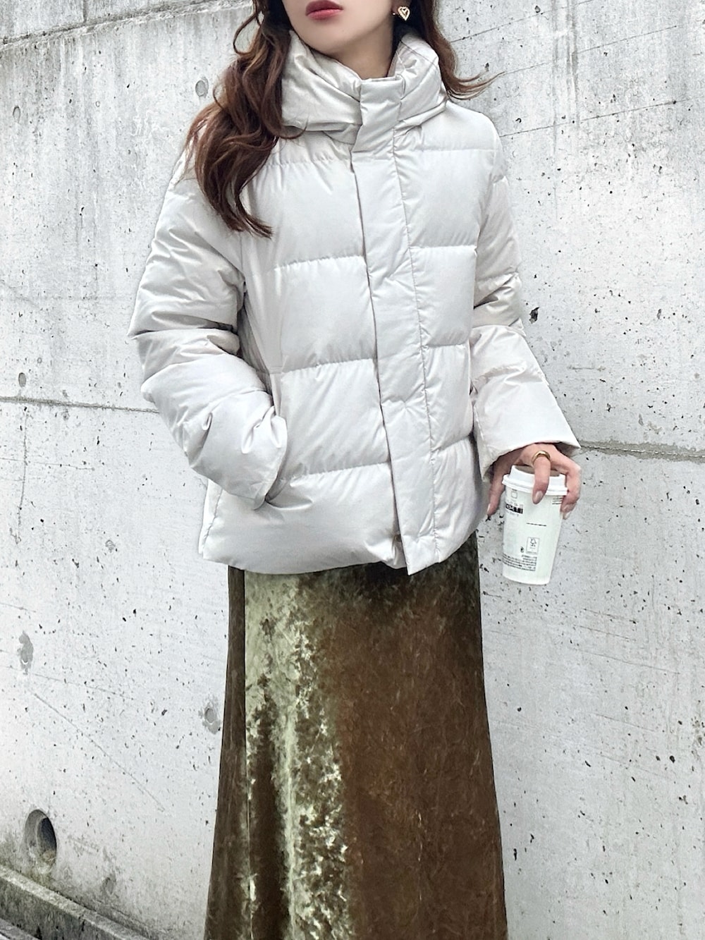 ホワイト系のブーツ、ホワイト系のダウンジャケット/コート、ベージュ系のスカートを着用したレディースの冬コーディネートの3枚目の写真