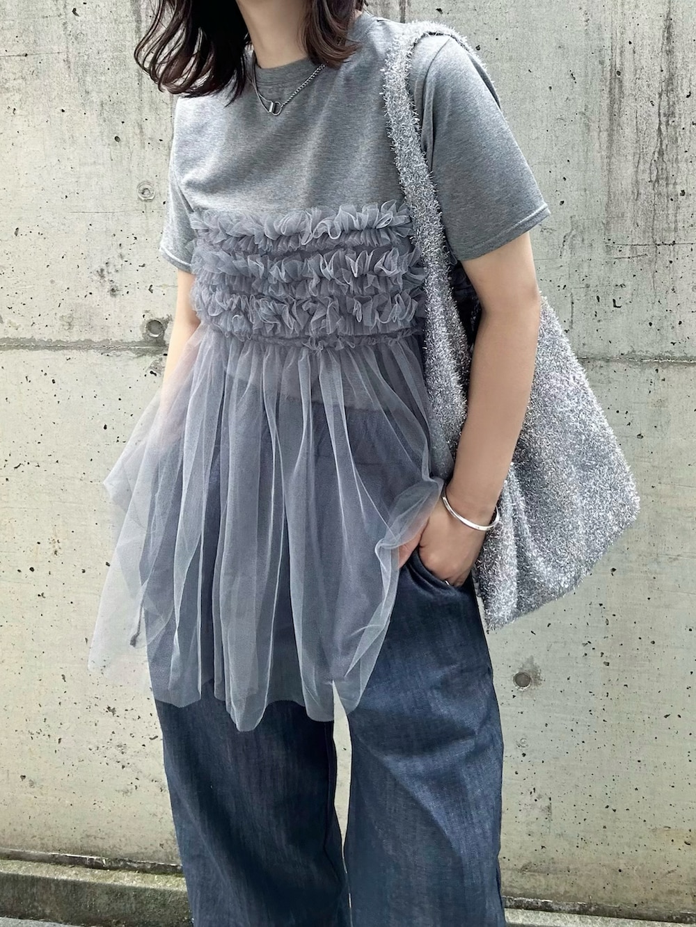 グレー系のTシャツ/カットソー、シルバー系のショルダーバッグ、ブルー系のデニムパンツを着用したレディースの夏コーディネートの5枚目の写真