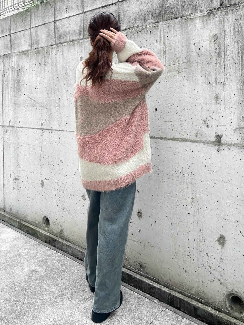 ホワイト系のカーディガン/ボレロ、ホワイト系のキャミソール、ブルー系のデニムパンツを着用したレディースの秋コーディネートの3枚目の写真