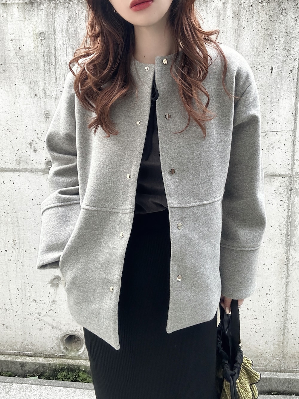 グレー系のTシャツ/カットソー、グレー系のノーカラーコート、ブラック系のスカートを着用したレディースの秋コーディネートの5枚目の写真