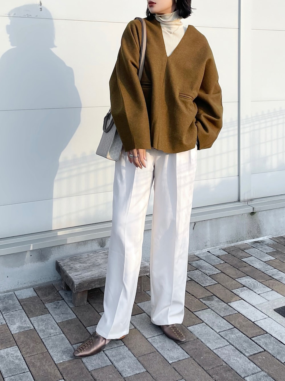 グリーン系のTシャツ/カットソー、ホワイト系のスラックス、その他のパンプスを着用したレディースの冬コーディネートの2枚目の写真