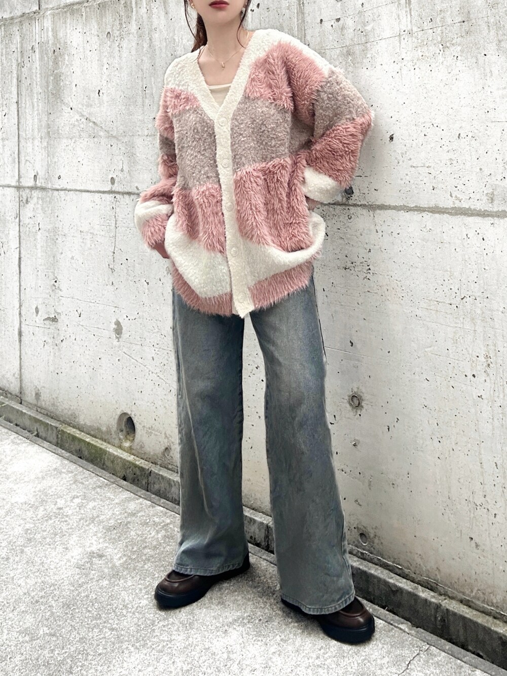 ホワイト系のカーディガン/ボレロ、ホワイト系のキャミソール、ブルー系のデニムパンツを着用したレディースの秋コーディネートの2枚目の写真