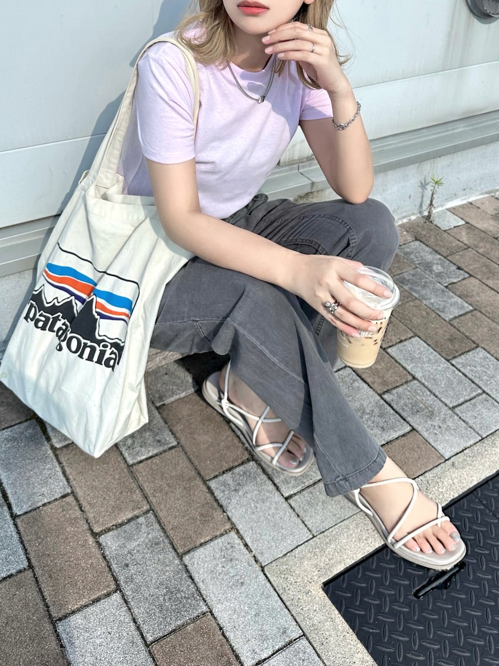 ホワイト系のTシャツ/カットソー、グレー系のパンツ、その他のトートバッグを着用したレディースの夏コーディネートの3枚目の写真