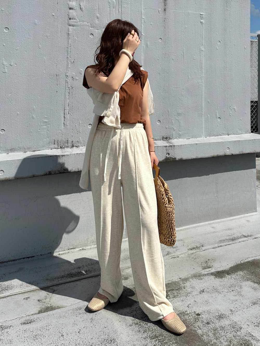 ベージュ系のその他パンツ、ブラウン系のかごバッグ、ブラウン系のタンクトップを着用したレディースの夏コーディネートの3枚目の写真