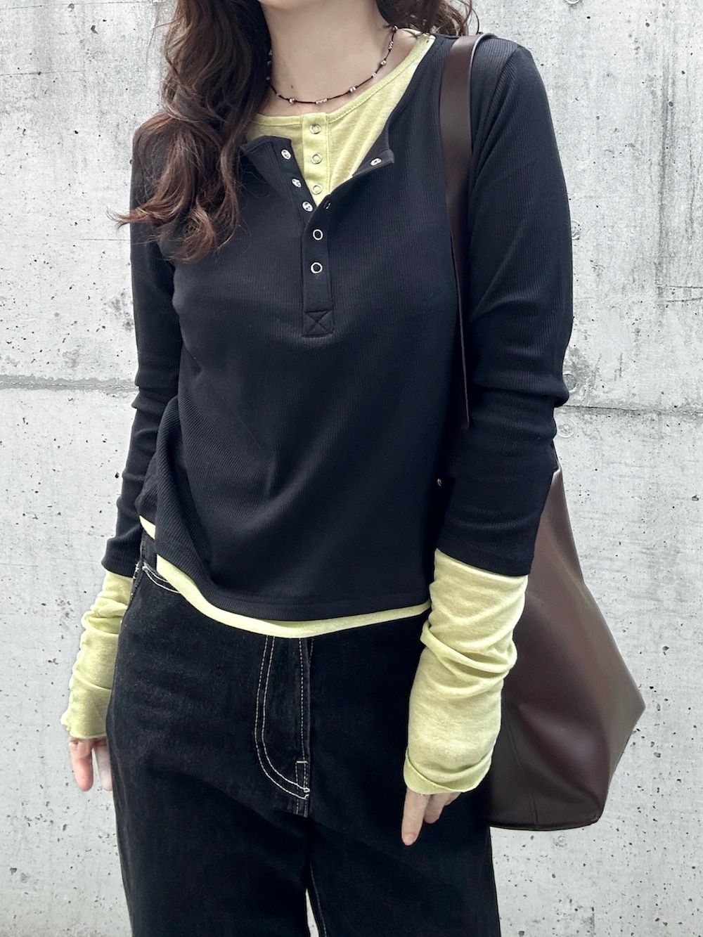 ブラック系のTシャツ/カットソー、ブラック系のデニムパンツ、ブラウン系のトートバッグを着用したレディースの春コーディネートの3枚目の写真