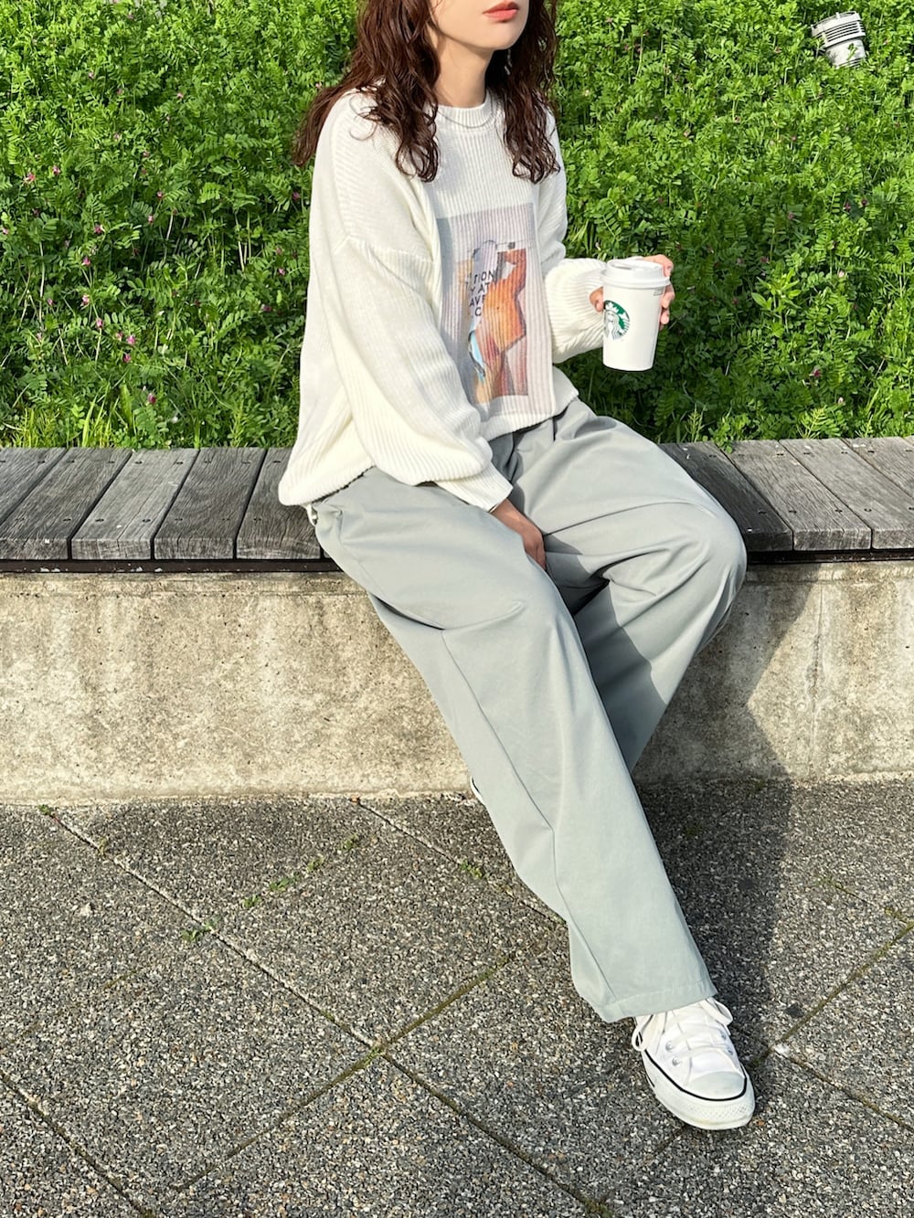 ホワイト系のニット/セーター、グリーン系のチノパンツ、ホワイト系のスニーカーを着用したレディースの春コーディネートの2枚目の写真