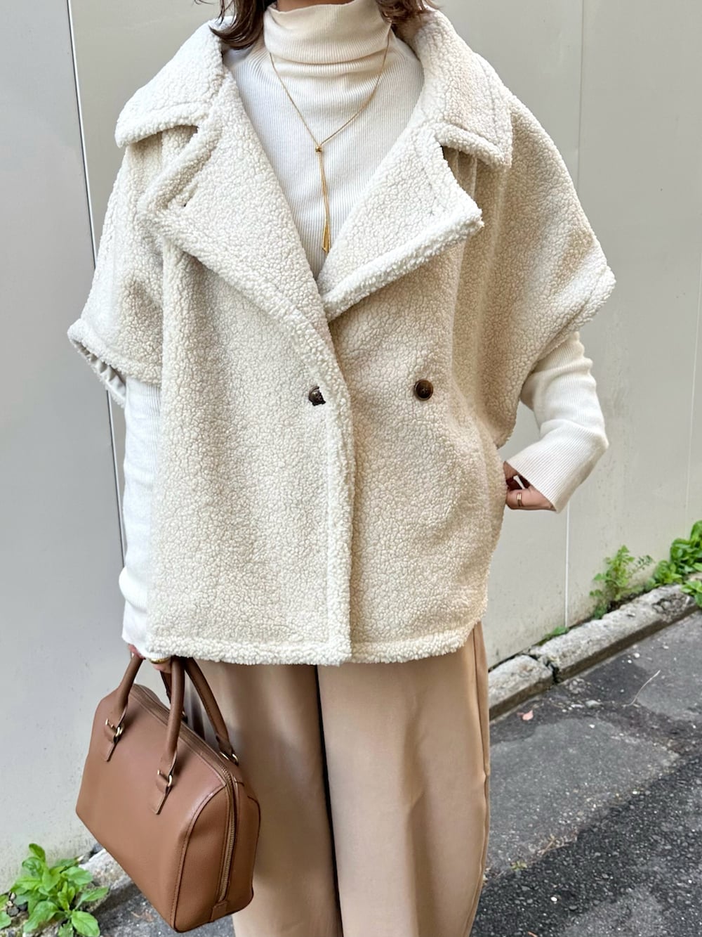 ホワイト系のステンカラーコート、ベージュ系のその他パンツ、ホワイト系のニット/セーターを着用したレディースの冬コーディネートの5枚目の写真