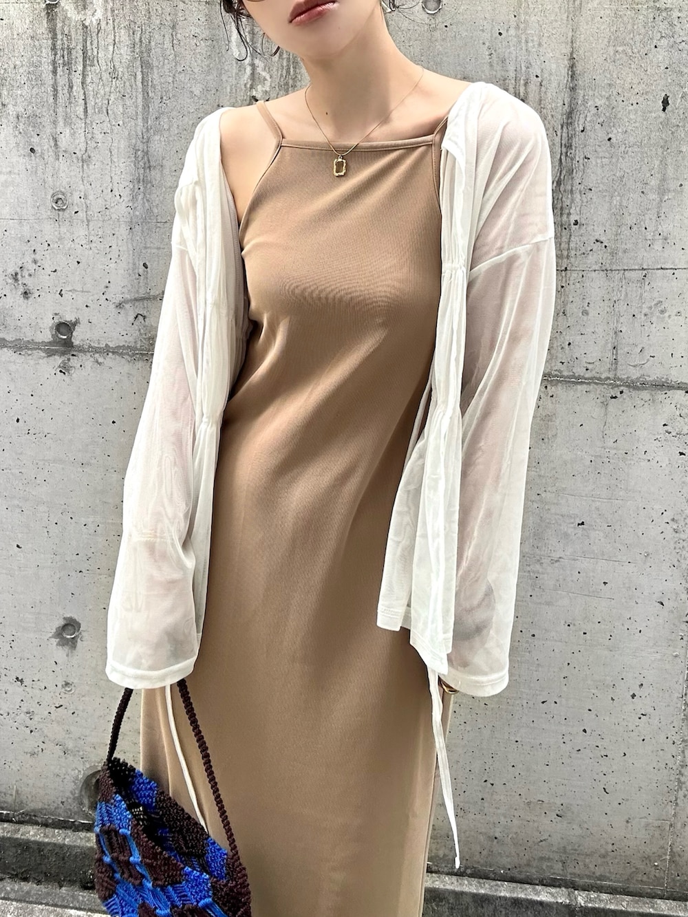 ベージュ系のワンピース、ホワイト系のシャツ/ブラウス、ブラウン系のバッグを着用したレディースの夏コーディネートの4枚目の写真