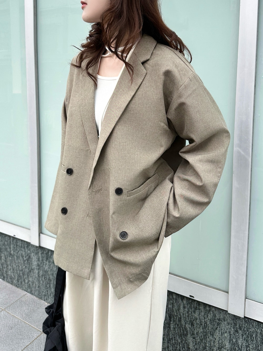 ブラウン系のテーラードジャケット、ホワイト系のTシャツ/カットソー、ホワイト系のスラックスを着用したレディースの春コーディネートの4枚目の写真