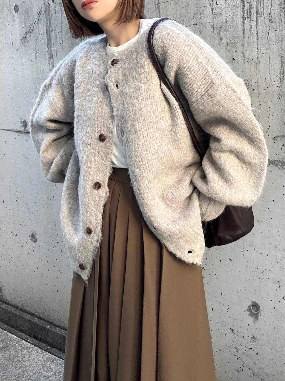 ベージュ系のカーディガン/ボレロ、ホワイト系のTシャツ/カットソー、ブラウン系のスカートを着用したレディースの秋コーディネートの5枚目の写真