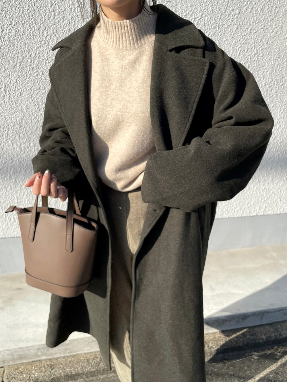 ブラック系のピーコート、ベージュ系のニット/セーター、グリーン系のその他パンツを着用したレディースの秋コーディネートの3枚目の写真