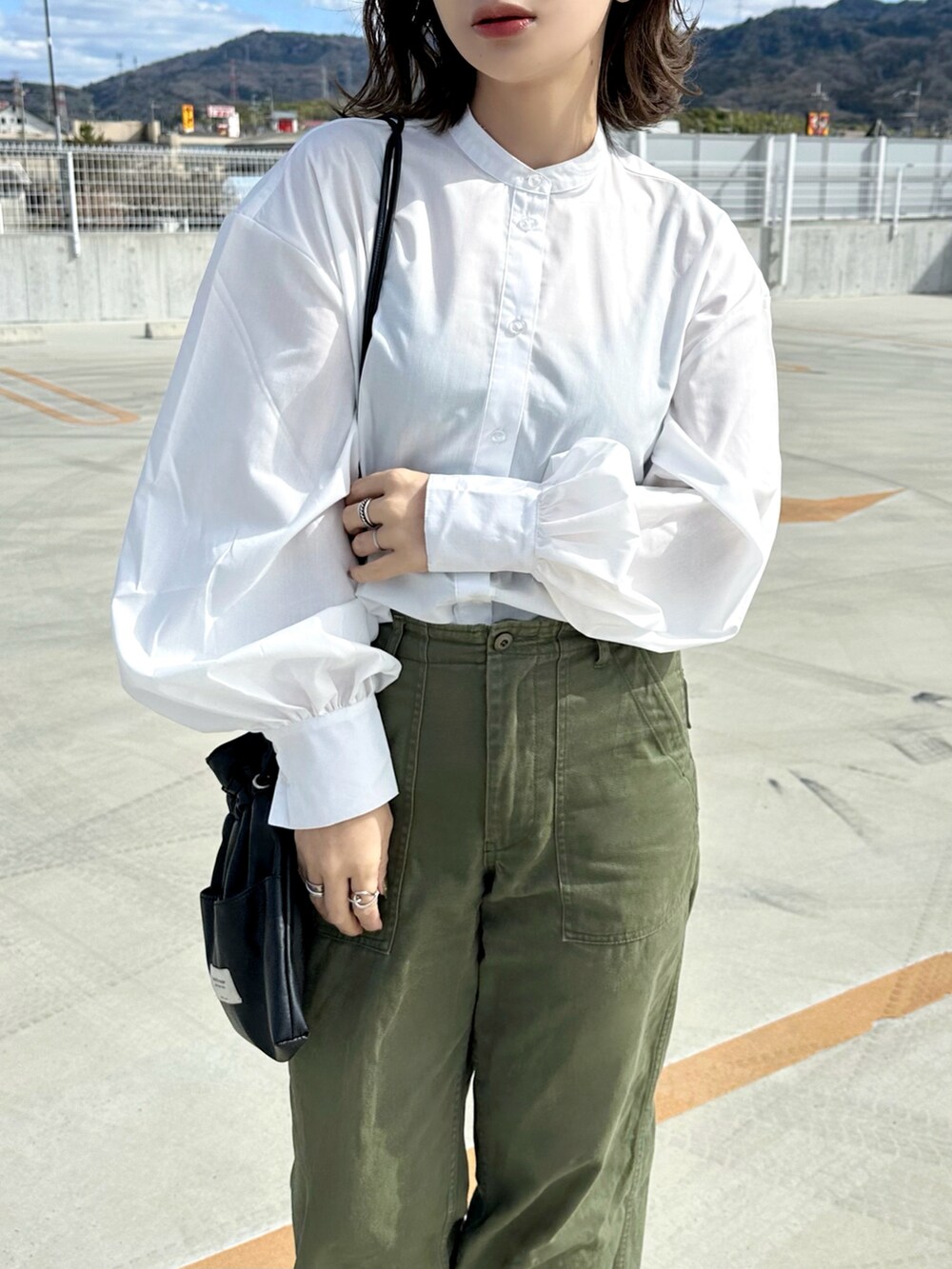 ホワイト系のシャツ/ブラウス、グリーン系のパンツ、ブラック系のショルダーバッグを着用したレディースの春コーディネートの4枚目の写真