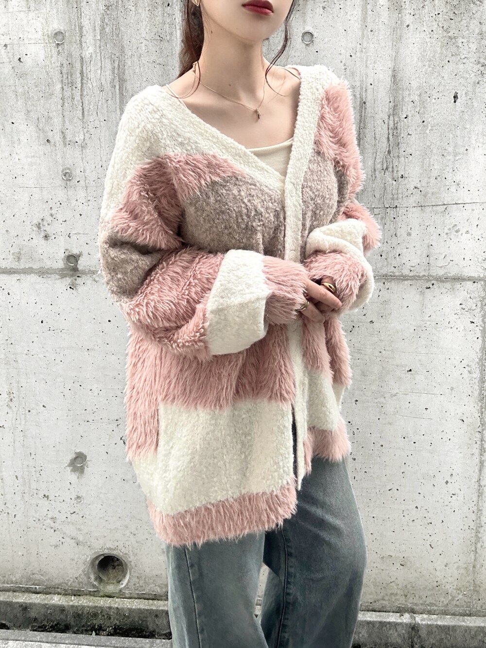 ホワイト系のカーディガン/ボレロ、ホワイト系のキャミソール、ブルー系のデニムパンツを着用したレディースの秋コーディネートの4枚目の写真