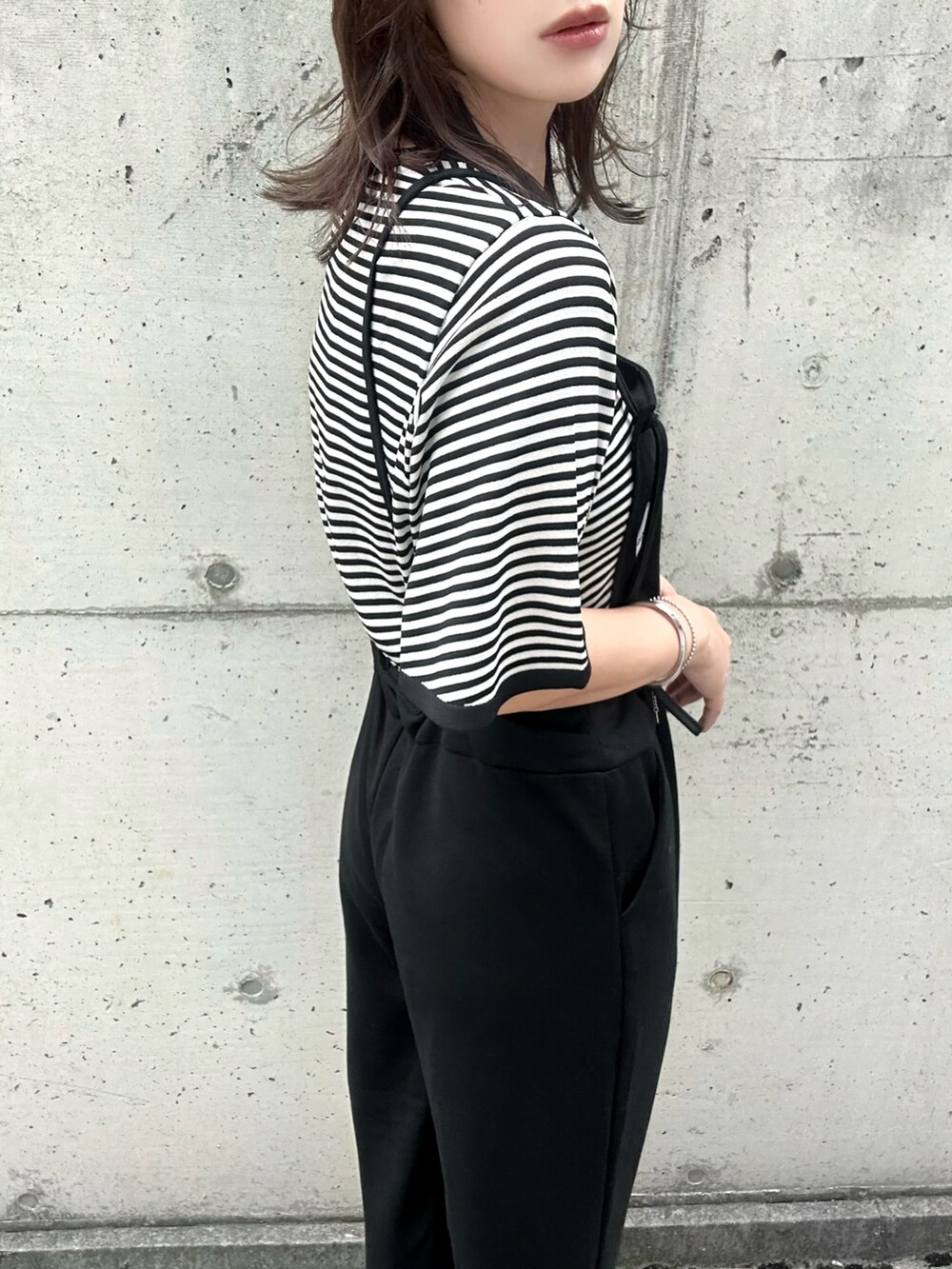 ベージュ系のニット/セーター、ホワイト系のサンダルを着用したレディースの夏コーディネートの4枚目の写真