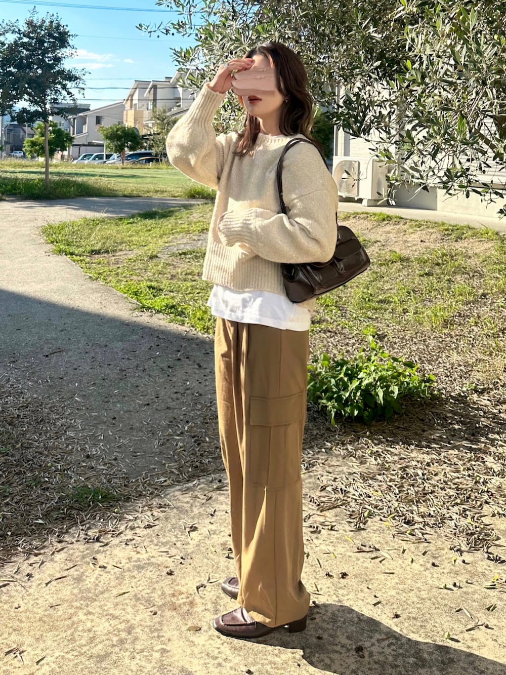 ベージュ系のニット/セーター、ブラウン系のパンツ、ブラウン系のショルダーバッグを着用したレディースの秋コーディネートの2枚目の写真