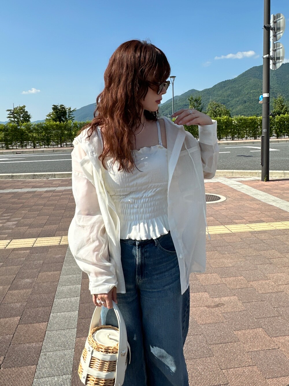 ホワイト系のシャツ/ブラウス、ホワイト系のキャミソール、ブルー系のデニムパンツを着用したレディースの夏コーディネートの2枚目の写真