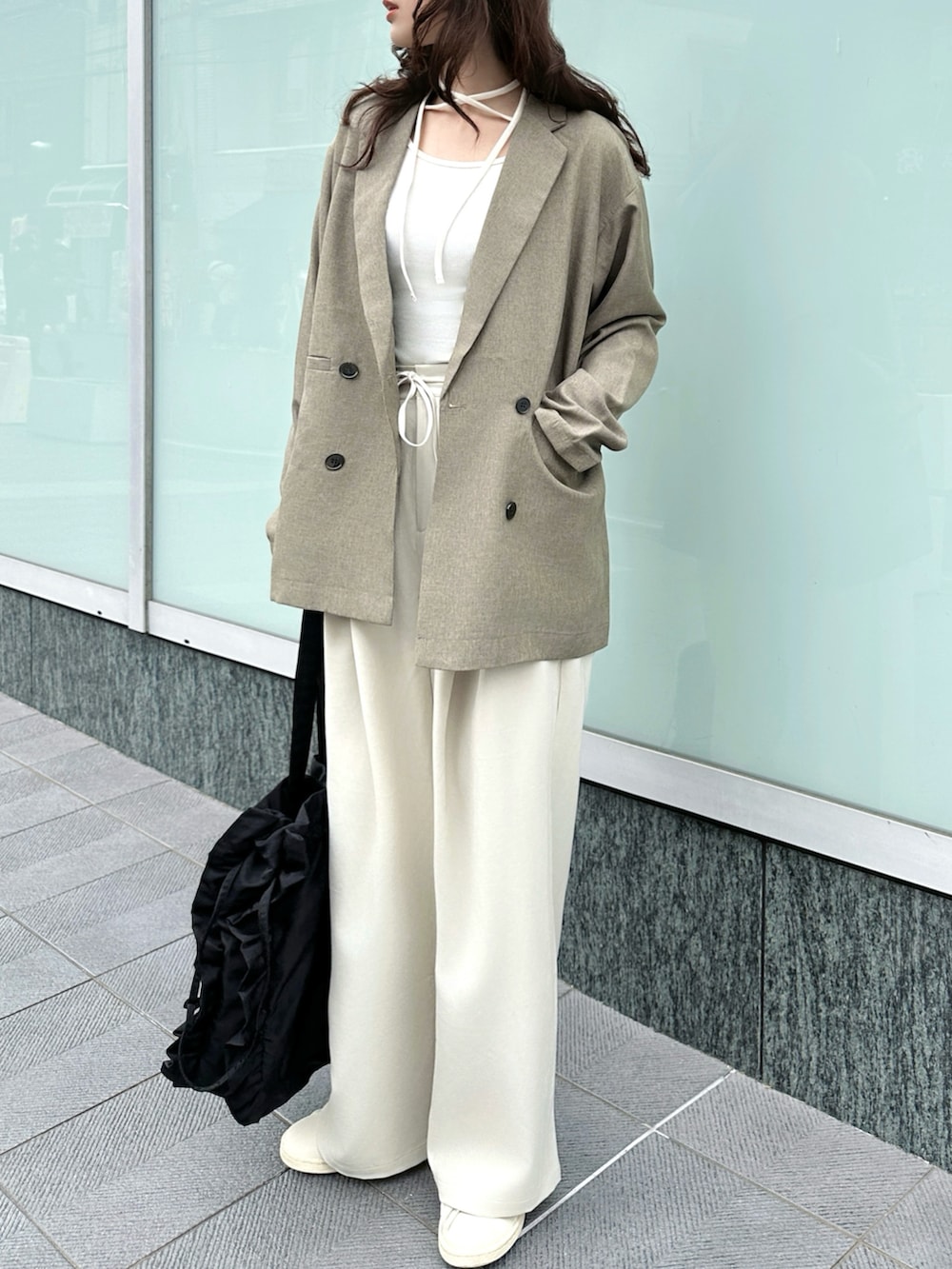 ブラウン系のテーラードジャケット、ホワイト系のTシャツ/カットソー、ホワイト系のスラックスを着用したレディースの春コーディネートの2枚目の写真