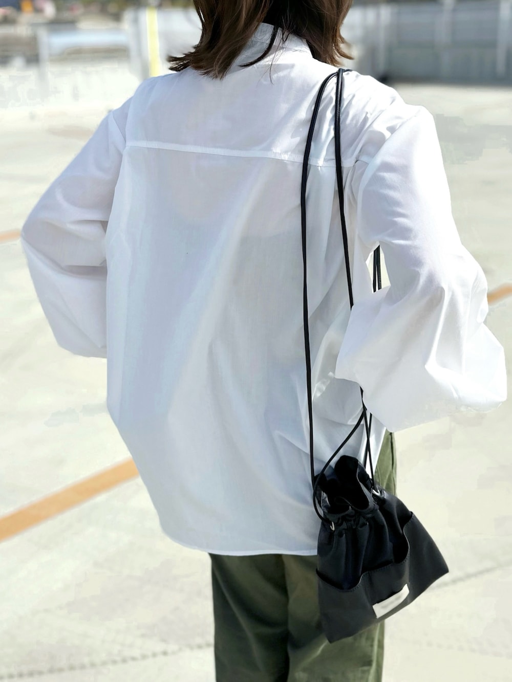 ホワイト系のシャツ/ブラウス、グリーン系のパンツ、ブラック系のショルダーバッグを着用したレディースの春コーディネートの5枚目の写真