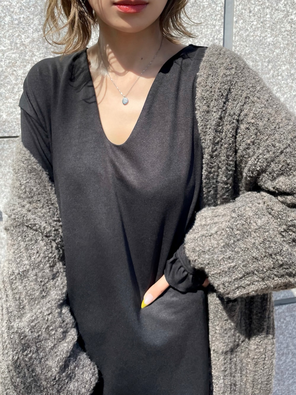 ブラック系のワンピース、ベージュ系のカーディガン/ボレロ、ブラウン系のバッグを着用したレディースの秋コーディネートの3枚目の写真