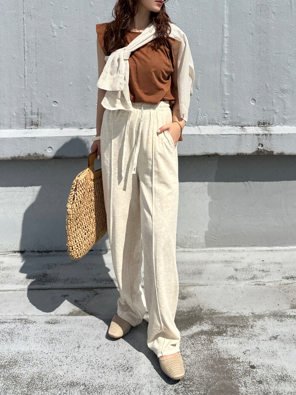 ベージュ系のその他パンツ、ブラウン系のかごバッグ、ブラウン系のタンクトップを着用したレディースの夏コーディネートの2枚目の写真
