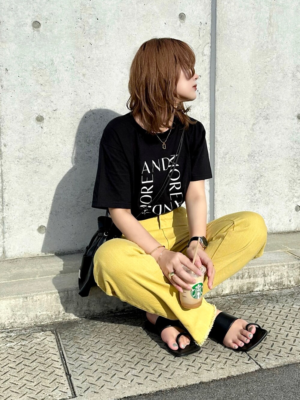 ブラック系のTシャツ/カットソー、イエロー系のデニムパンツ、ブラック系のショルダーバッグを着用したレディースの夏コーディネートの4枚目の写真