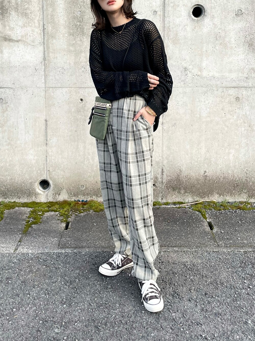 ブラック系のニット/セーター、グリーン系のスラックス、グリーン系のボディバッグ/ウエストポーチを着用したレディースの春コーディネートの2枚目の写真