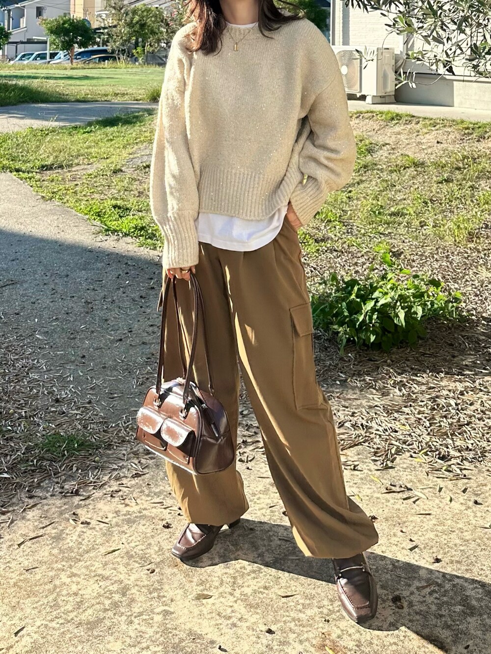ベージュ系のニット/セーター、ブラウン系のパンツ、ブラウン系のショルダーバッグを着用したレディースの秋コーディネートの4枚目の写真