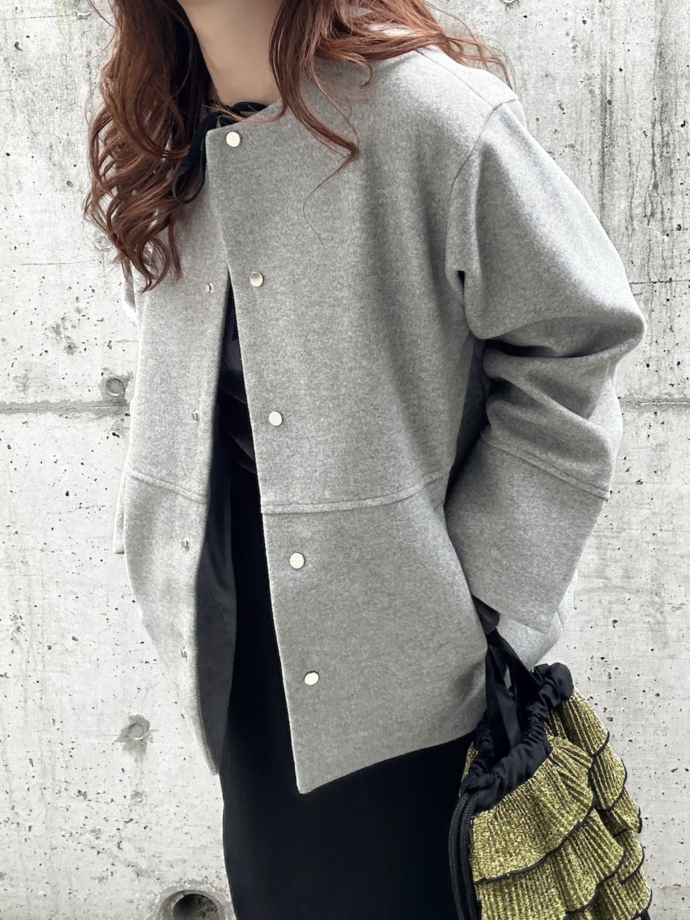 グレー系のTシャツ/カットソー、グレー系のノーカラーコート、ブラック系のスカートを着用したレディースの秋コーディネートの4枚目の写真