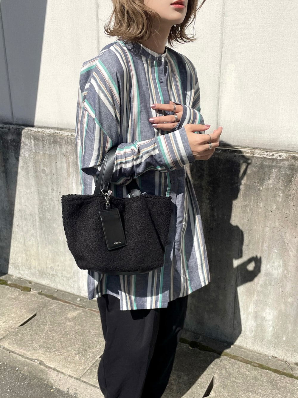 ブラック系のトートバッグ、ブルー系のシャツ/ブラウス、ブラック系のパンツを着用したレディースの秋コーディネートの2枚目の写真