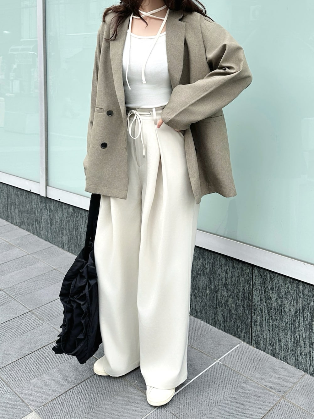 ブラウン系のテーラードジャケット、ホワイト系のTシャツ/カットソー、ホワイト系のスラックスを着用したレディースの春コーディネートの3枚目の写真